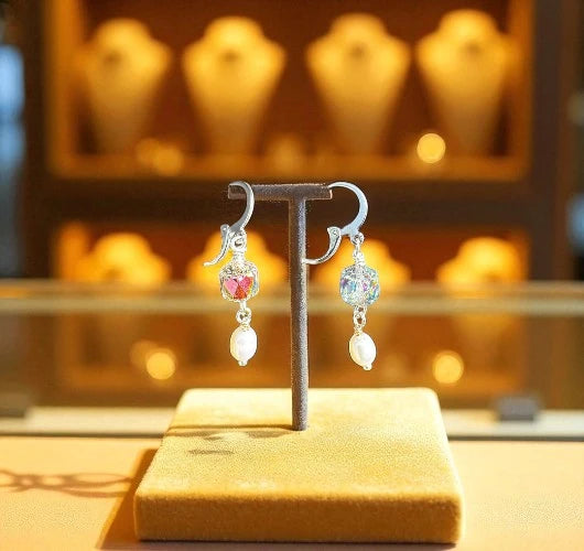 Pair of earrings on a display stand with a blurred jewelry store background