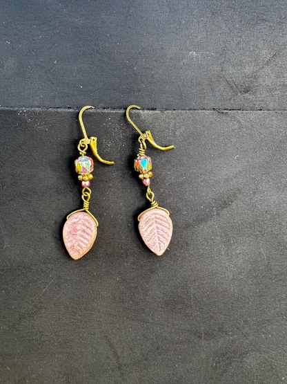 Handmade with Czech glass beads, these earrings have a celestial glow. They feature an antique bronze finish and brass hardware, including a leaf-shaped charm.