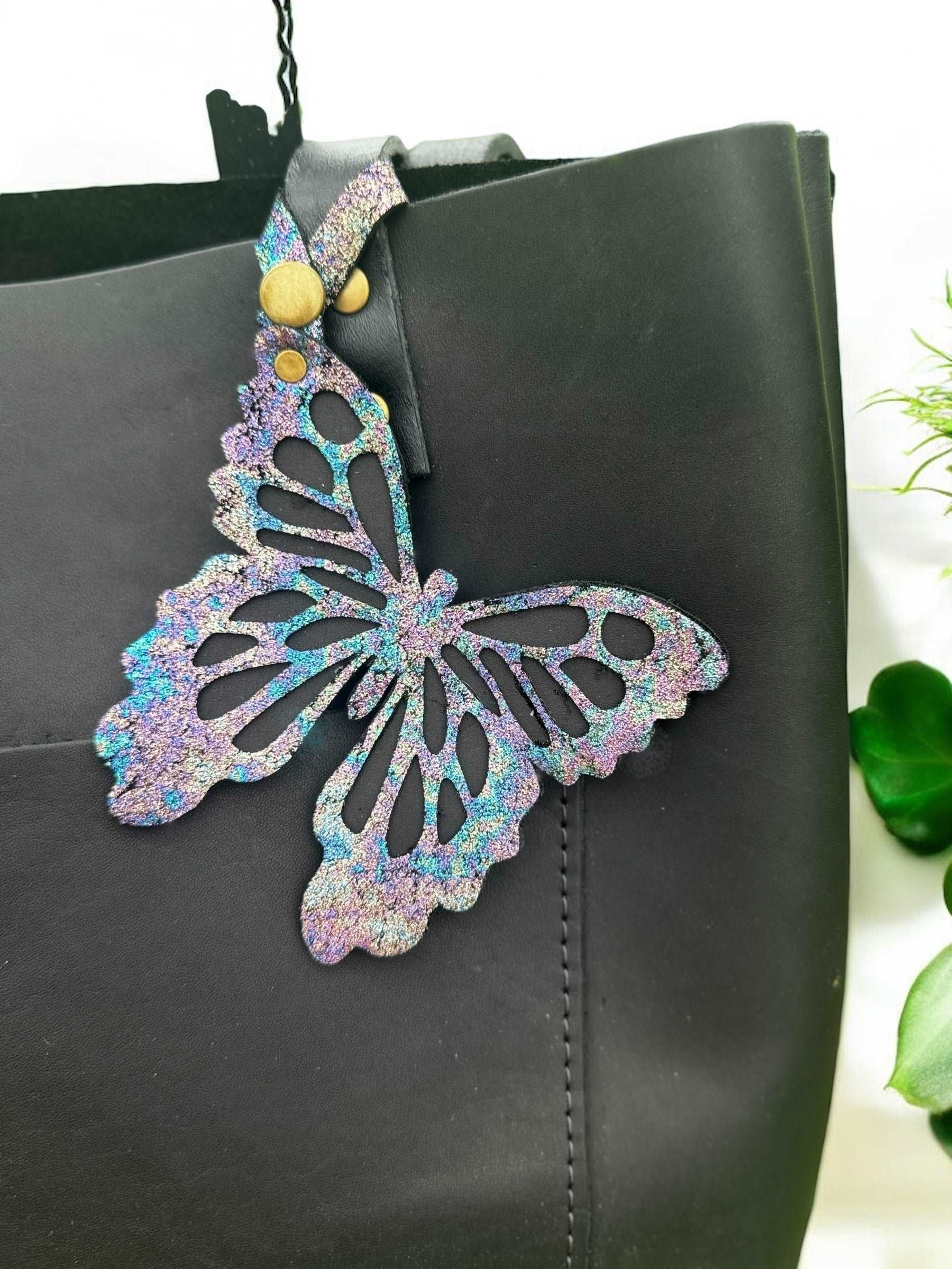 Unique leather butterfly charm with a chameleon-like color-shifting effect, crafted from halo metallic leather with a crackled texture and a snap closure for versatile use