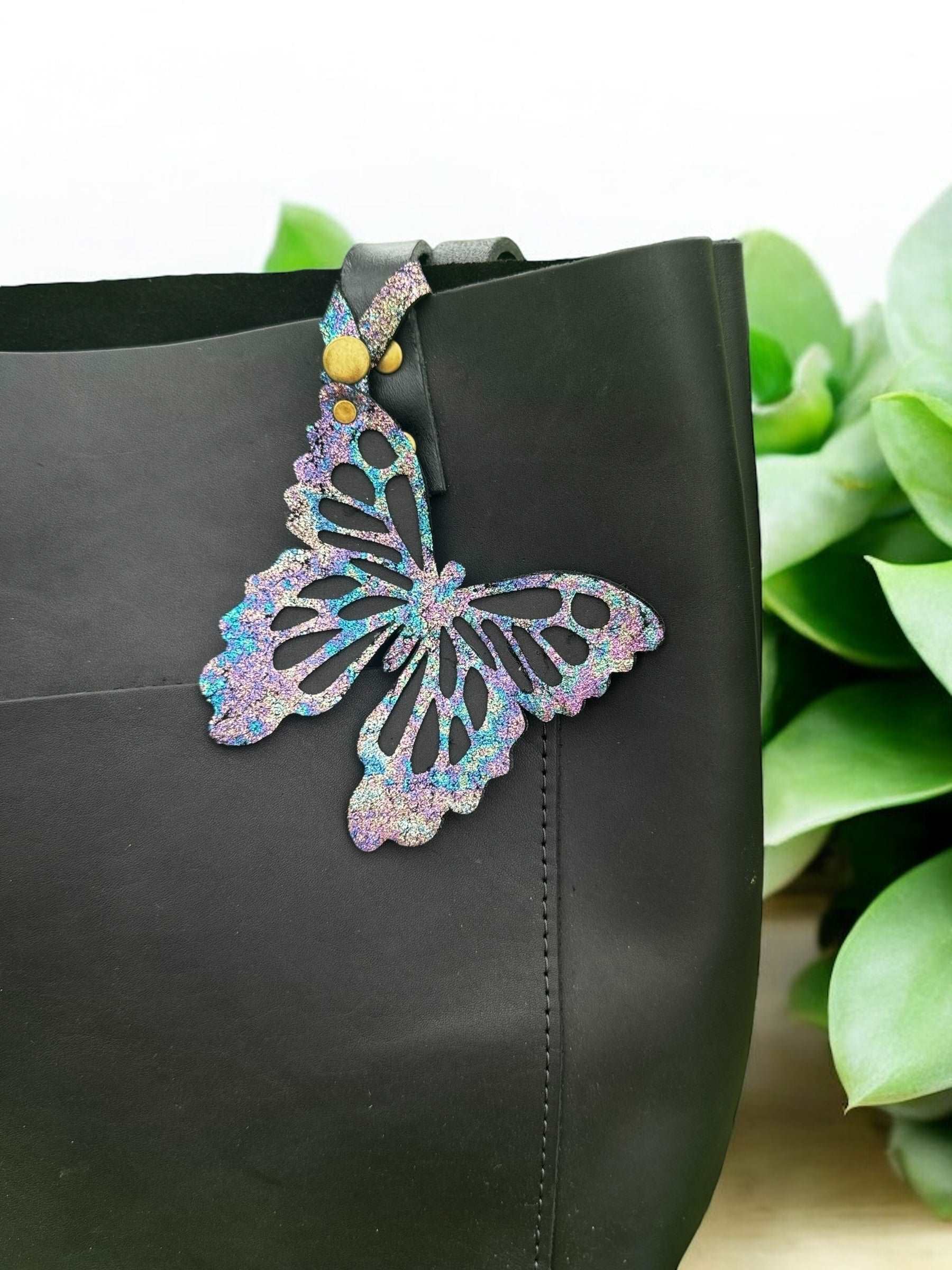 Unique leather butterfly charm with a chameleon-like color-shifting effect, crafted from halo metallic leather with a crackled texture and a snap closure for versatile use