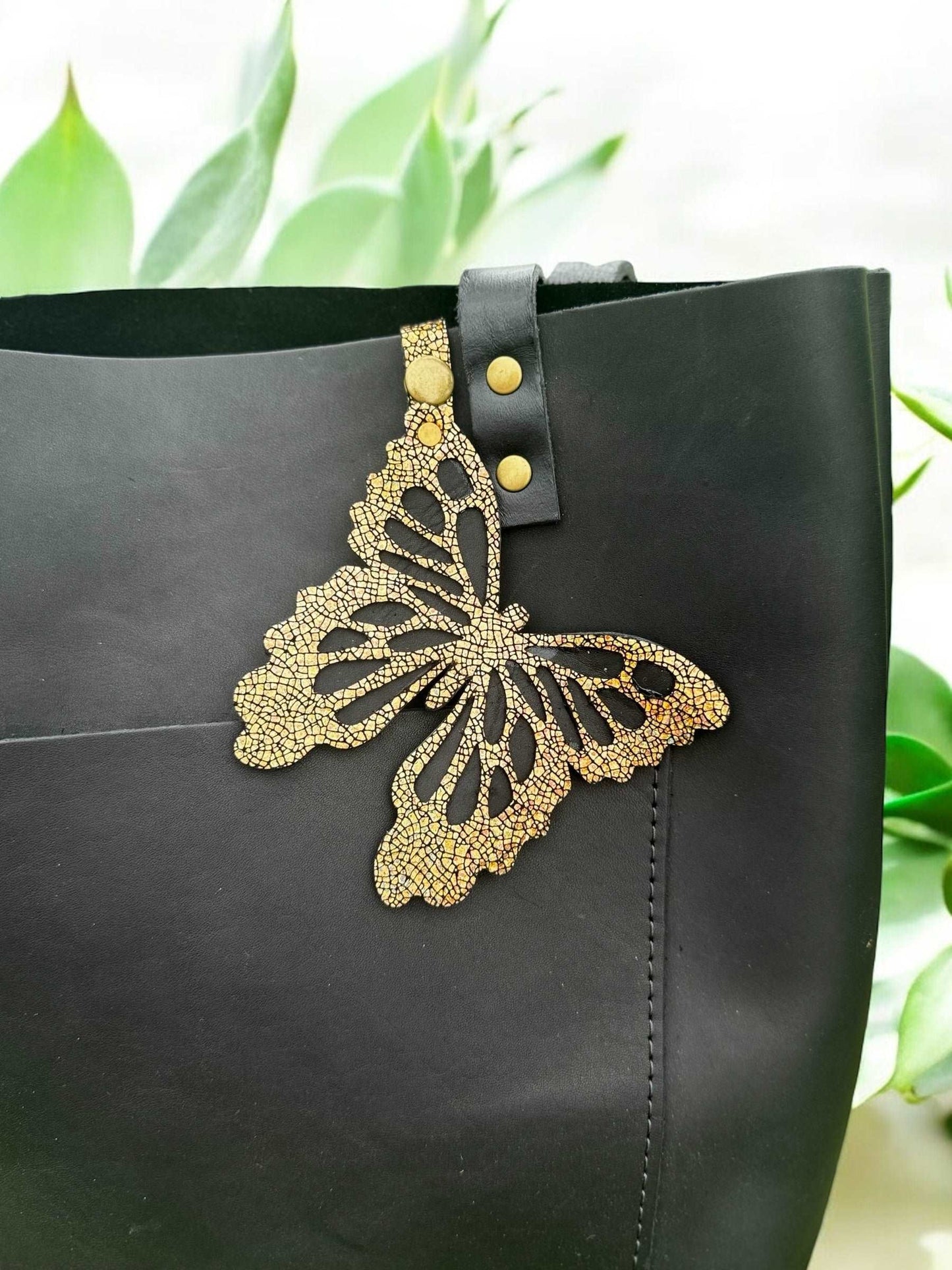 Luxurious leather butterfly charm in a crackled gold finish, made from halo metallic leather, with a snap closure for easy use as a purse accessory or keychain.