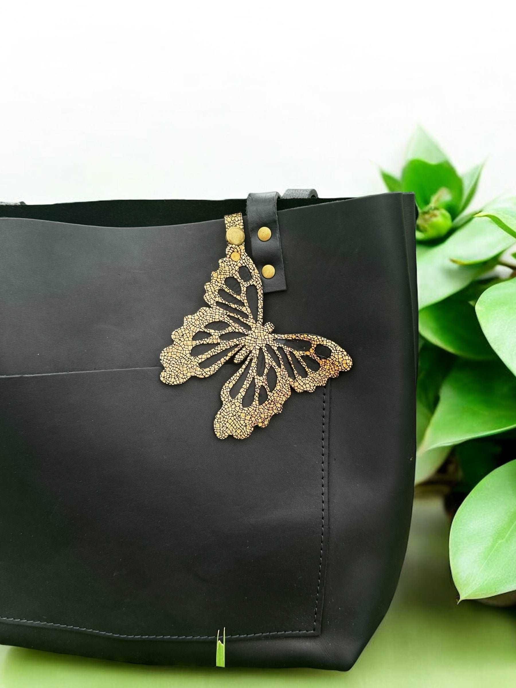 Luxurious leather butterfly charm in a crackled gold finish, made from halo metallic leather, with a snap closure for easy use as a purse accessory or keychain.