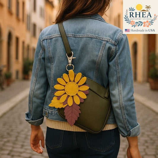 Person wearing a denim jacket with a green bag featuring a leather bag charm, set against an urban background.