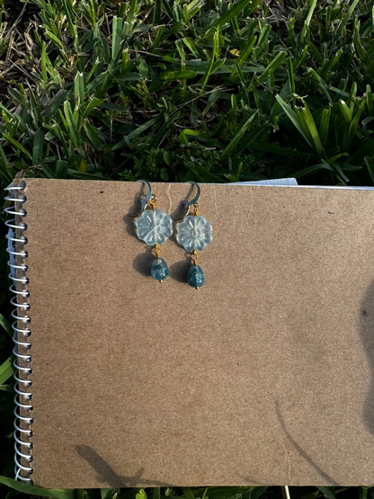 Floral earrings with blue beads on an old book