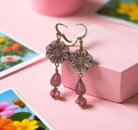 Floral earrings with pink beads on a pink surface with floral background