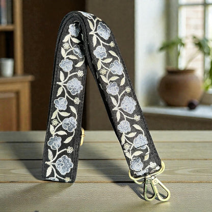 flat lay of Floral embroidery strap on a wooden surface with a blurred indoor background