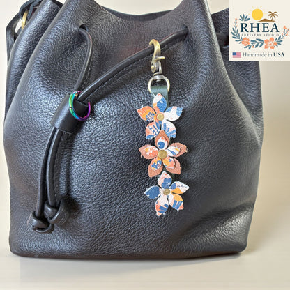 Handmade leather floral charm clipped to a handbag