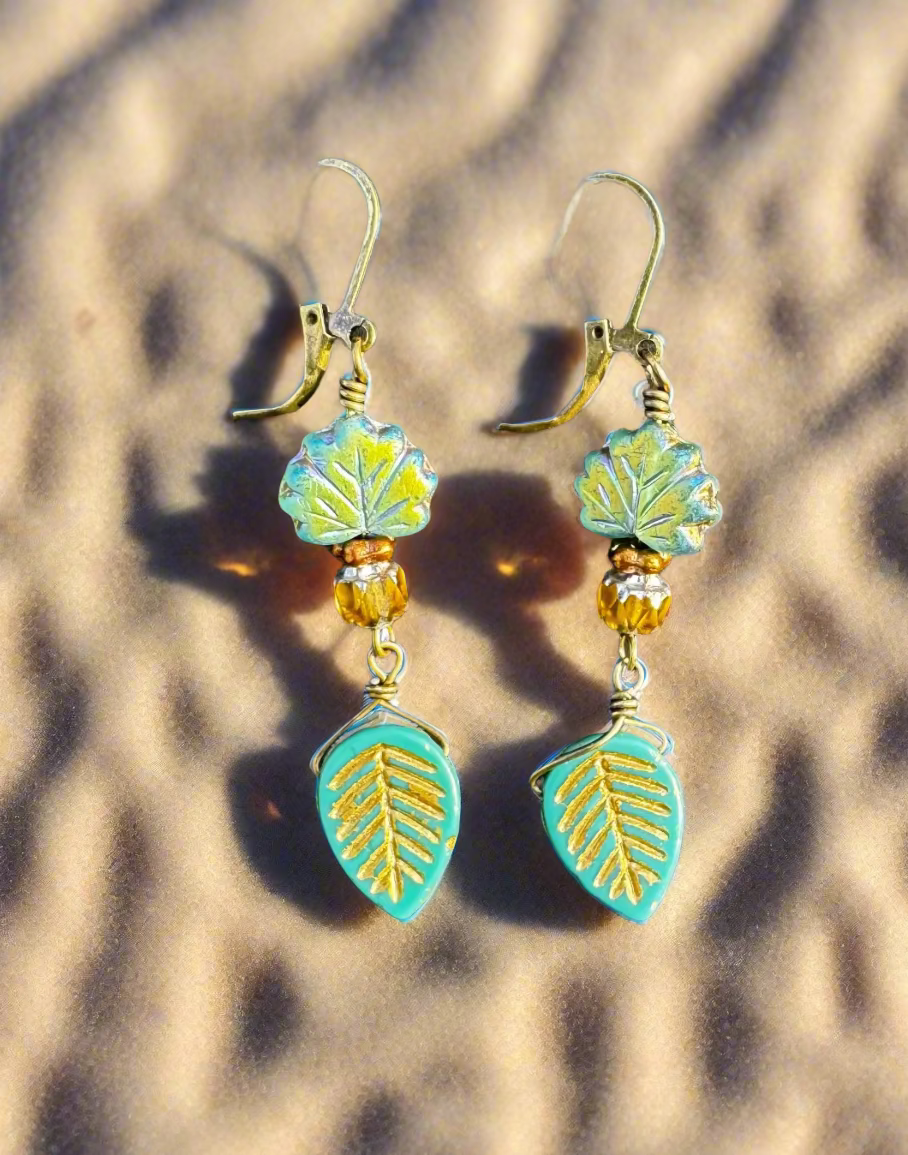 Pair of earrings with leaf designs on a black bag