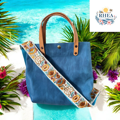 Ethically crafted embroidered replacement purse strap in aqua blue, featuring intricate sunflower motifs on a cream  background on a teal bag

