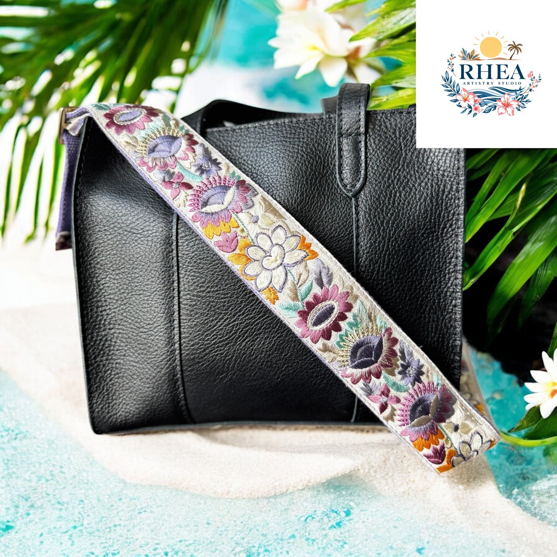 
Ethically crafted embroidered replacement purse strap in lavender, featuring intricate sunflower motifs on a cream background on a black bag at beach