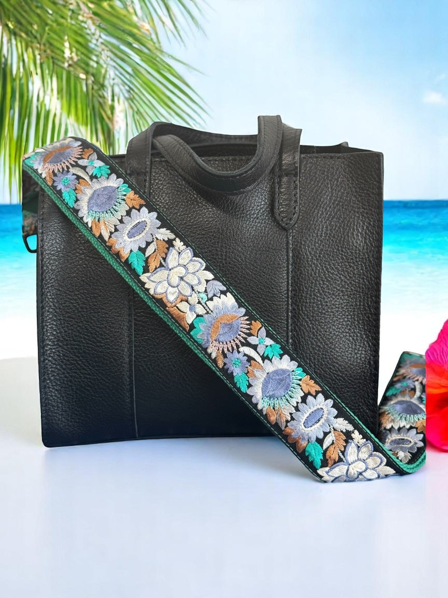 Ethically crafted embroidered replacement purse strap in sea foam green featuring intricate sunflower motifs on a black background at beach