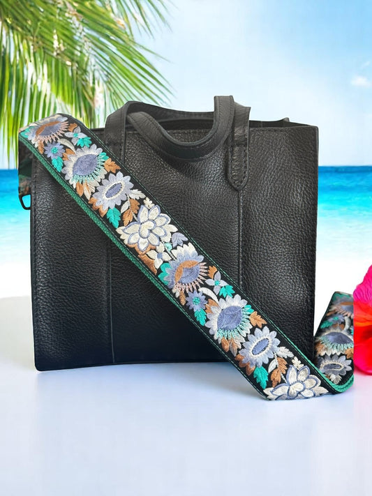Ethically crafted embroidered replacement purse strap in sea foam green featuring intricate sunflower motifs on a black background at beach