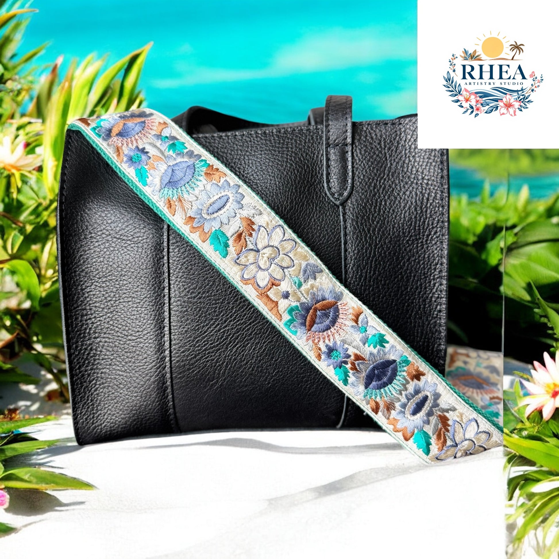 Ethically crafted embroidered replacement purse strap in sea foam green featuring intricate sunflower motifs on a cream background at beach on a black bag