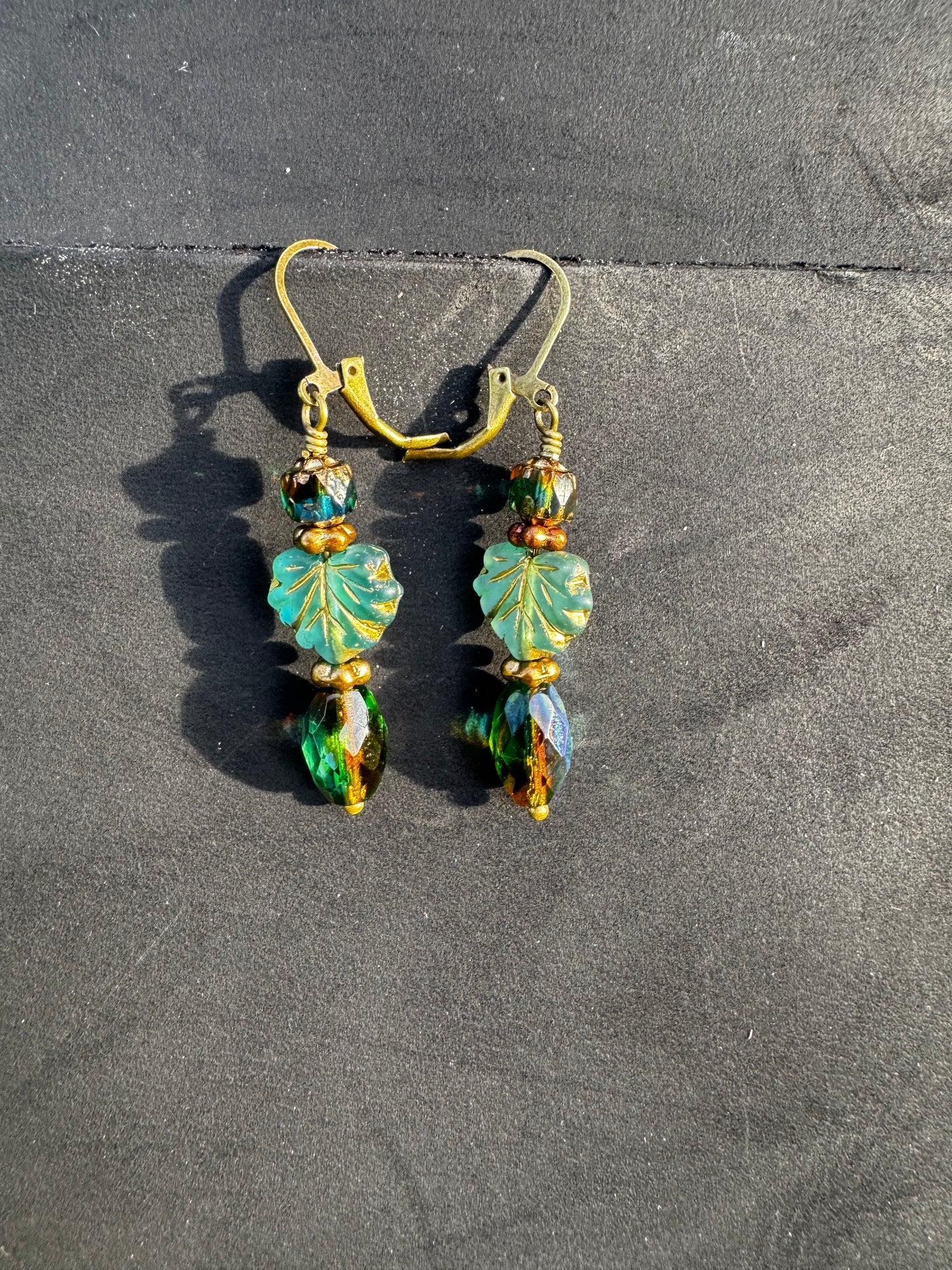  Handmade Czech glass earrings with celestial glow. Perfect for adding elegance to any outfit. Green drop ,leaf and cathedral bead