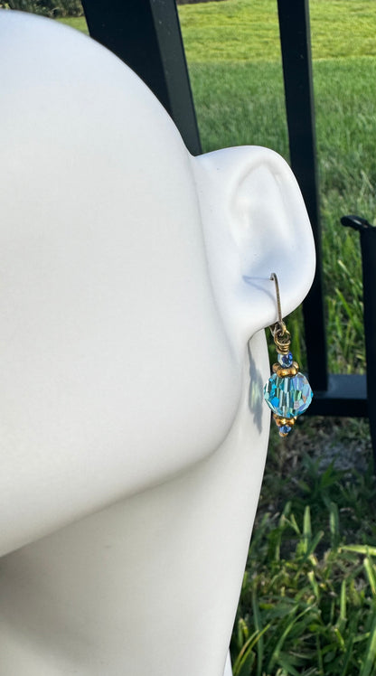 Gold and blue beaded earrings on a model