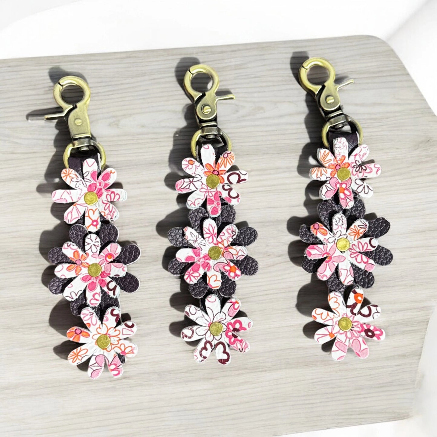 Leather daisy charm keychain with layered floral design and lobster clasp
