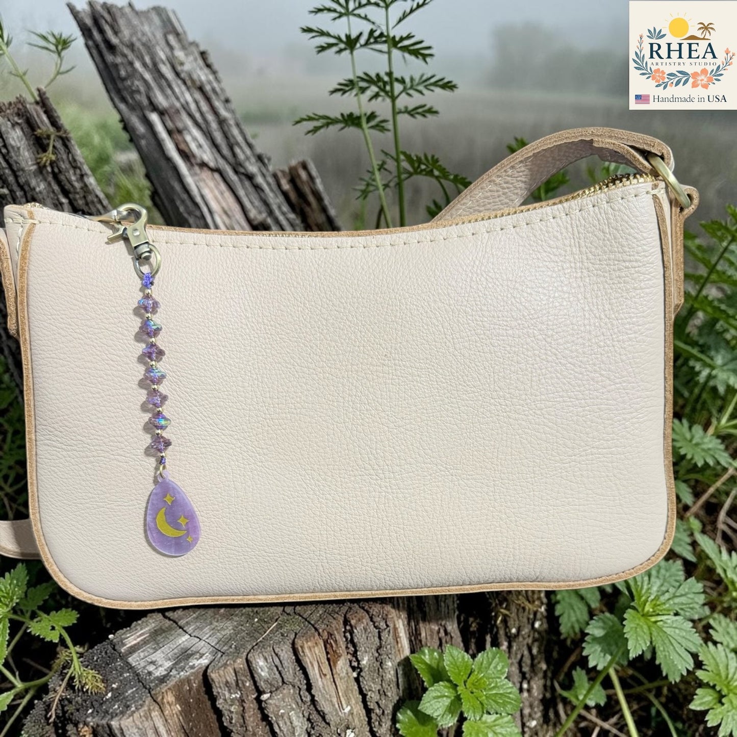 Beige handbag with a decorative keychain on a natural background