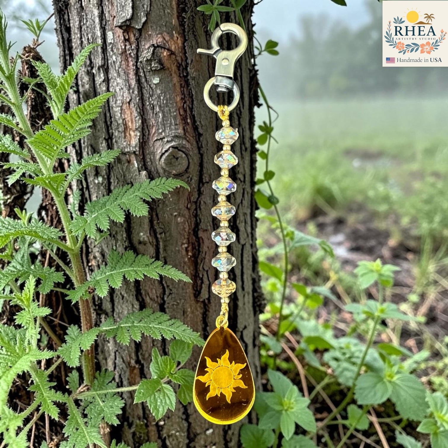 Keychain with sun design hanging from a tree