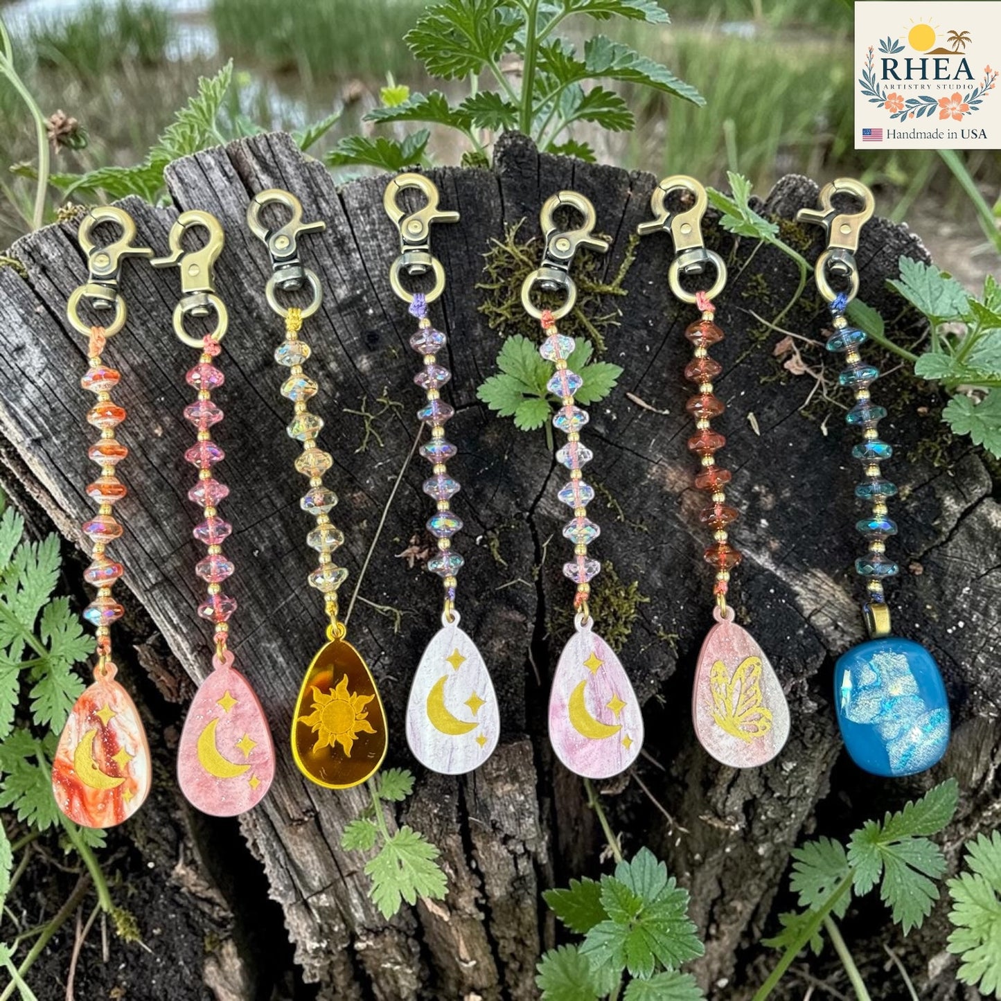 Colorful beaded keychains with nature-themed designs on a wooden surface.