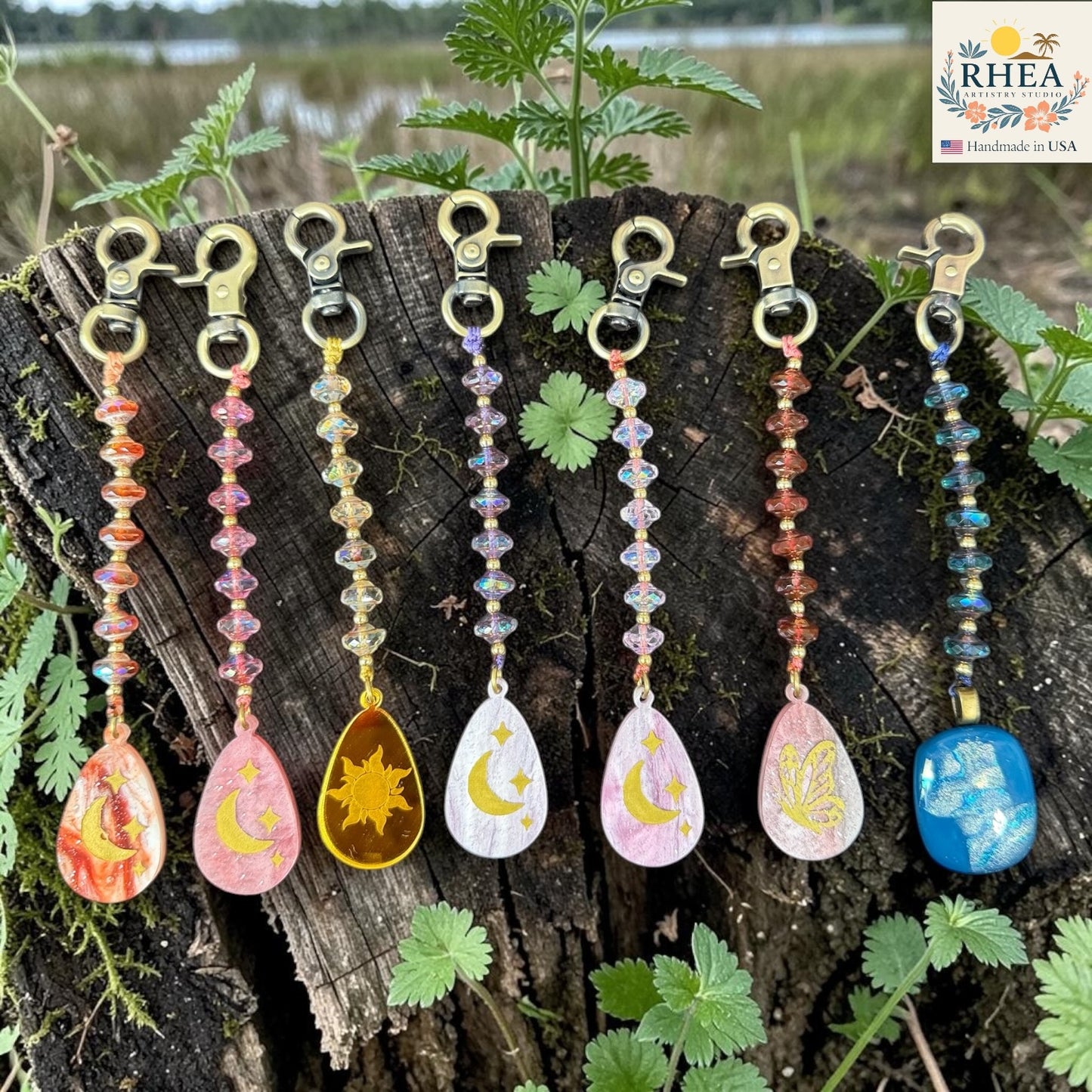 Set of colorful keychains with nature-themed designs on a wooden surface.