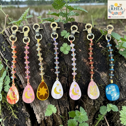 Set of colorful keychains with nature-themed designs on a wooden surface.
