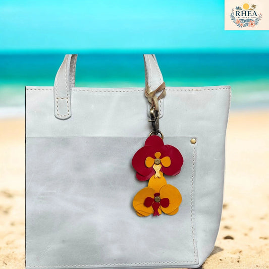 White handbag with a colorful flower charm on a beach background