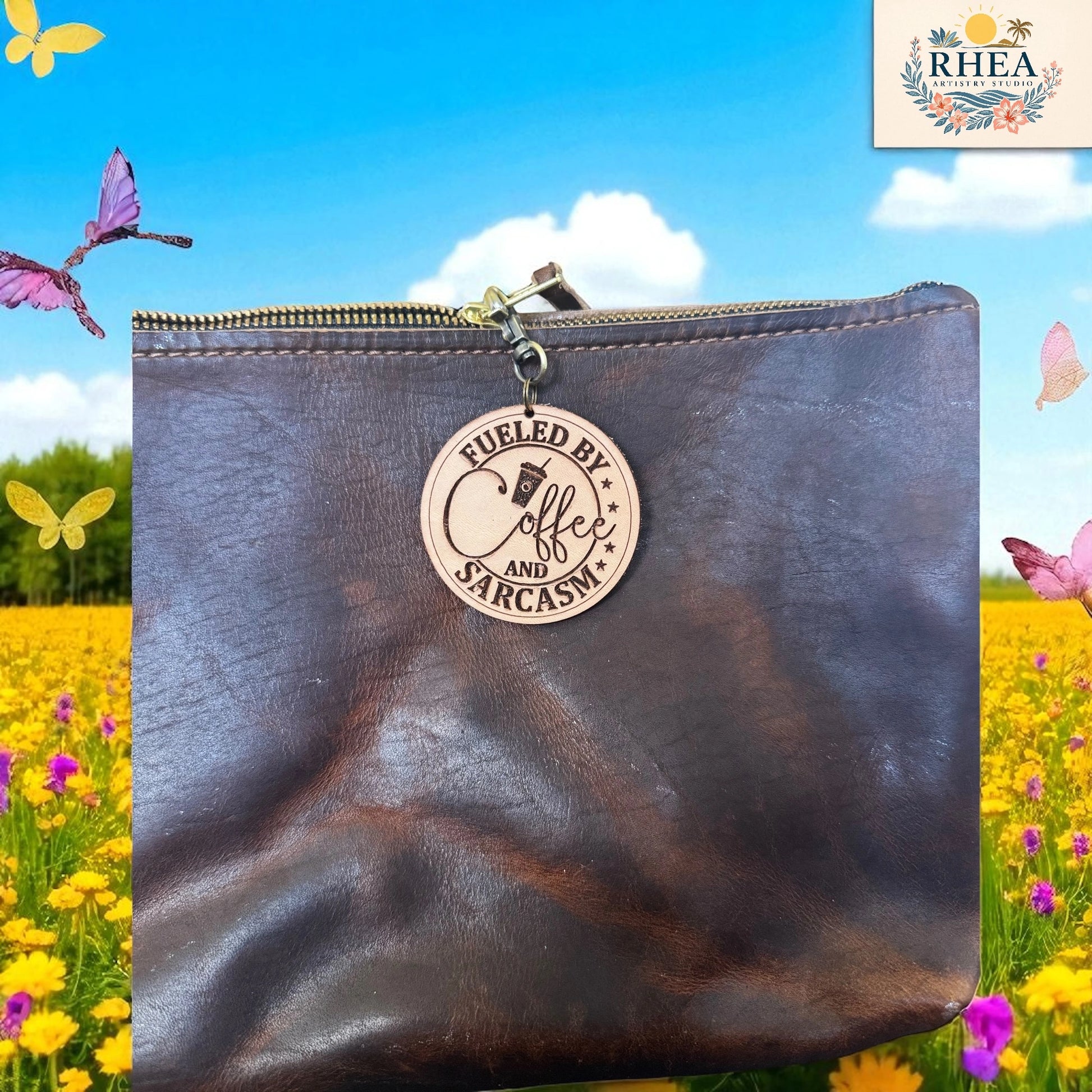 Brown leather pouch with a wooden tag reading 'Fueled by Coffee and Sarcasm' against a colorful background with flowers and butterflies.