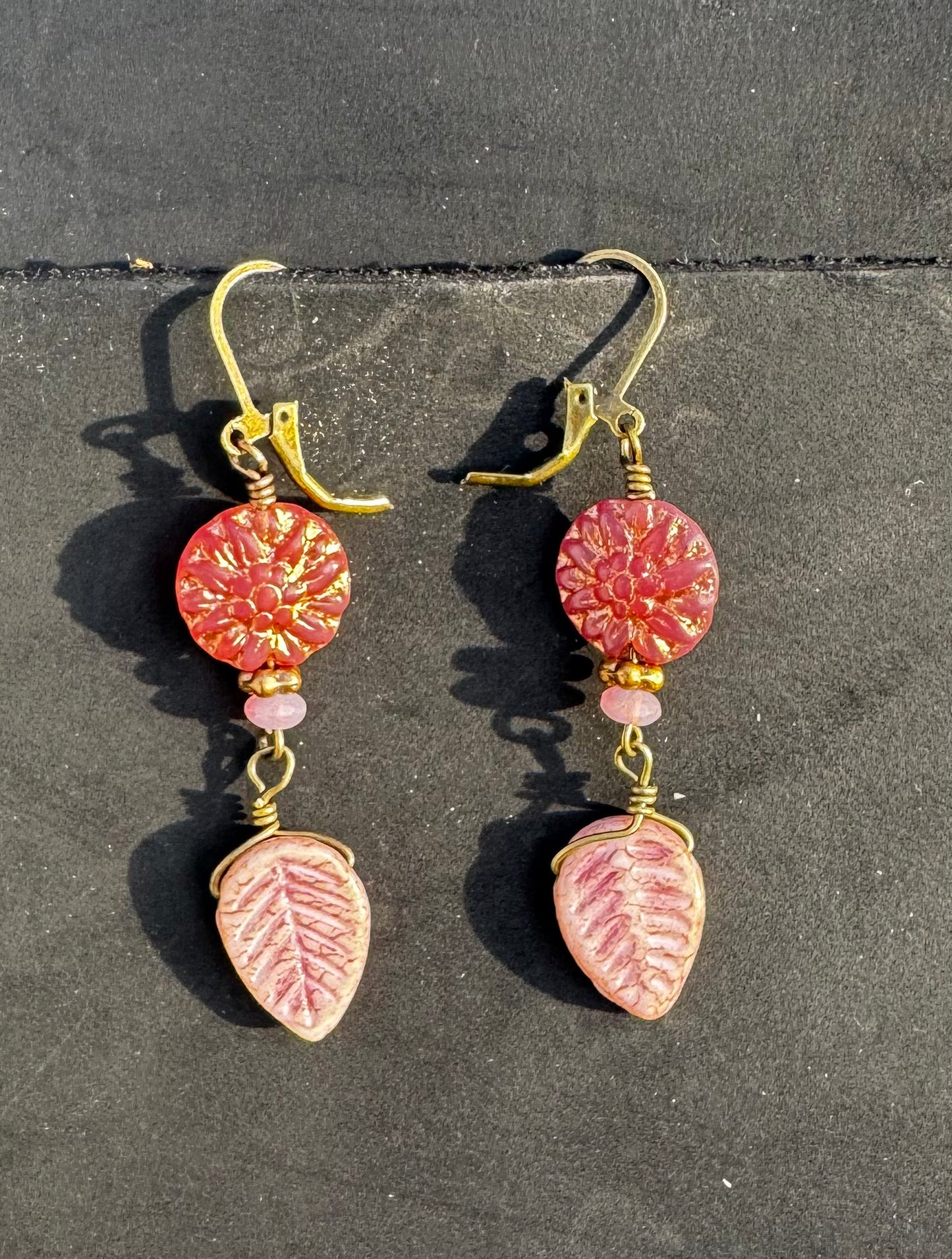 pink dahlia earrings with pink beads on a black bag