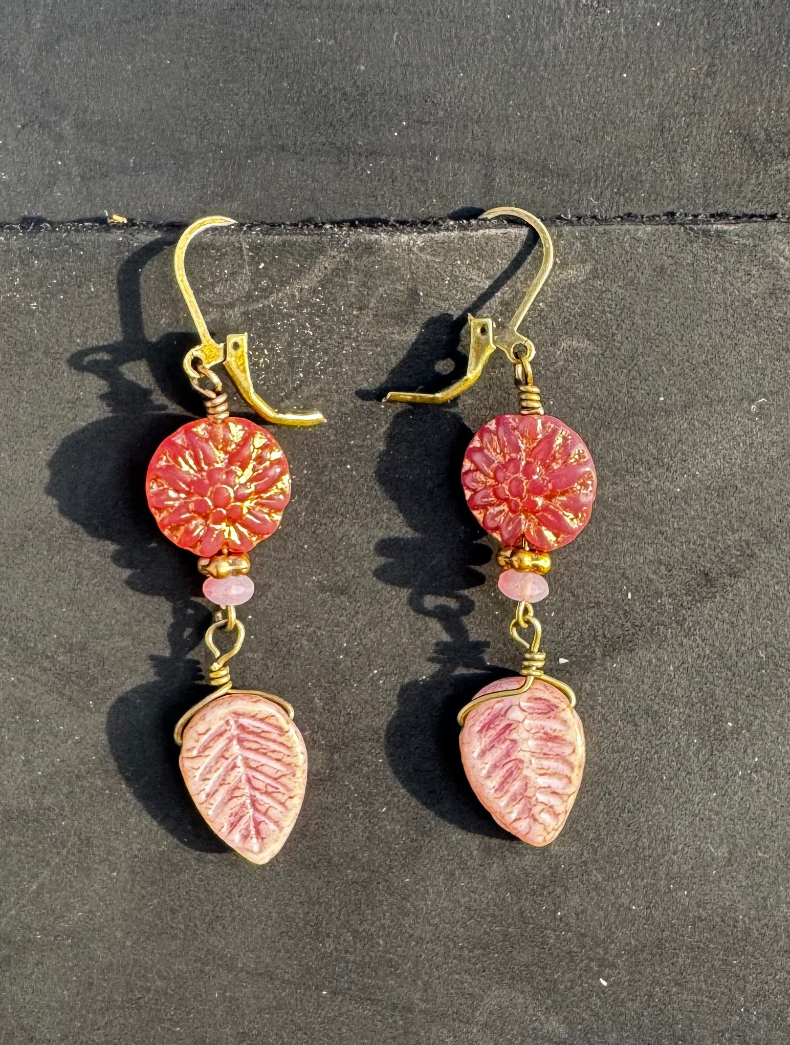 pink dahlia earrings with pink beads on a black bag