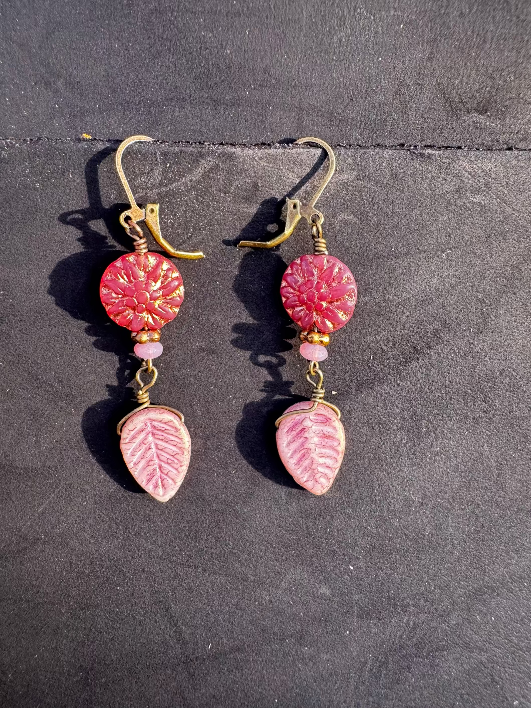 pink dahlia earrings with pink beads on a black bag