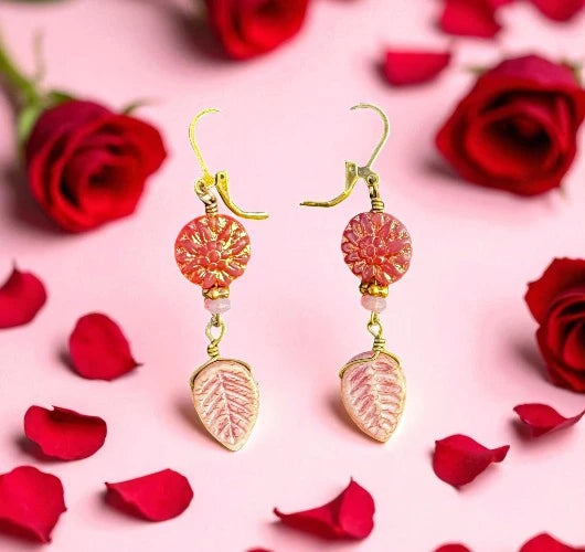 pink dahlia earrings on a pink background with red roses and petals
