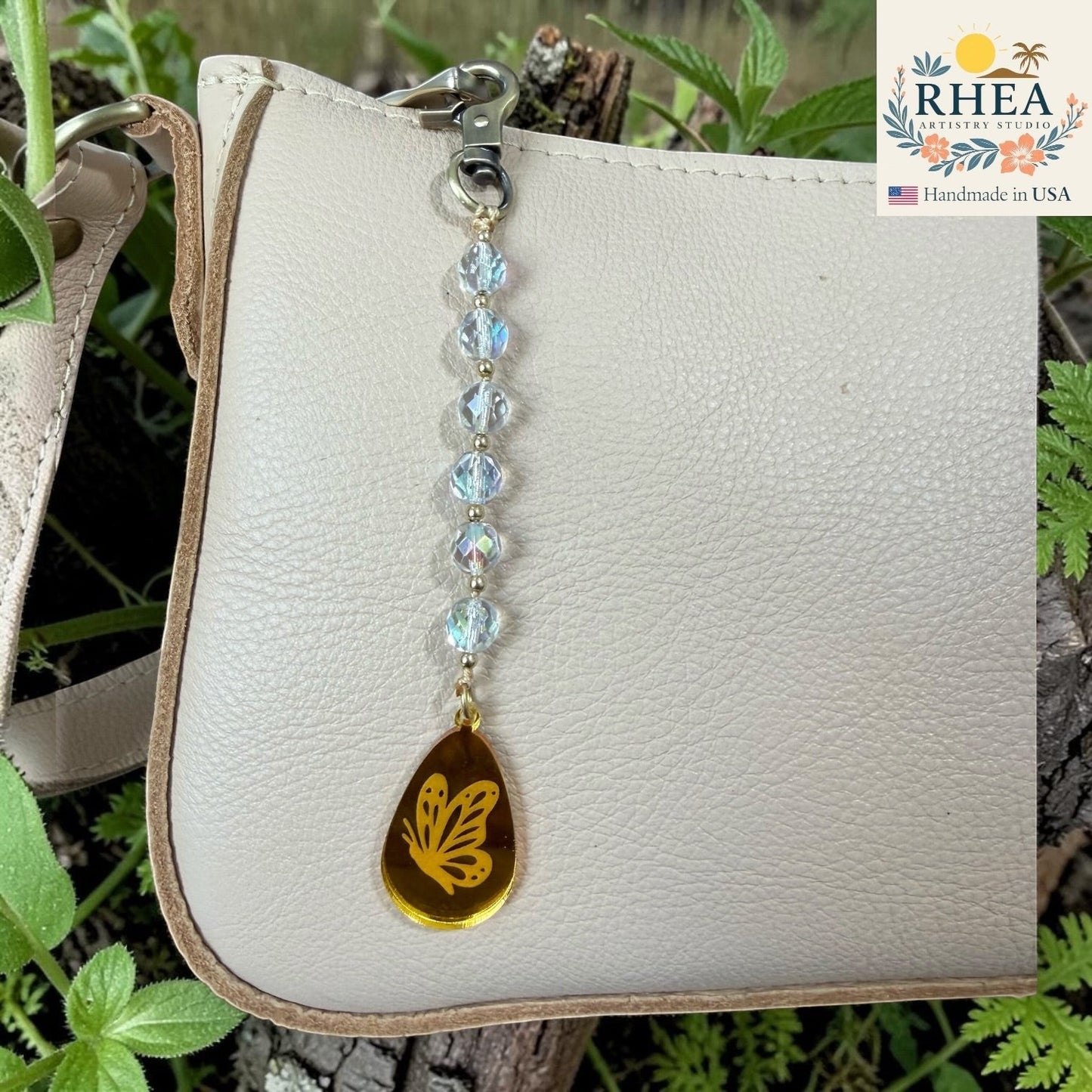 White leather wallet with a butterfly charm on a natural background