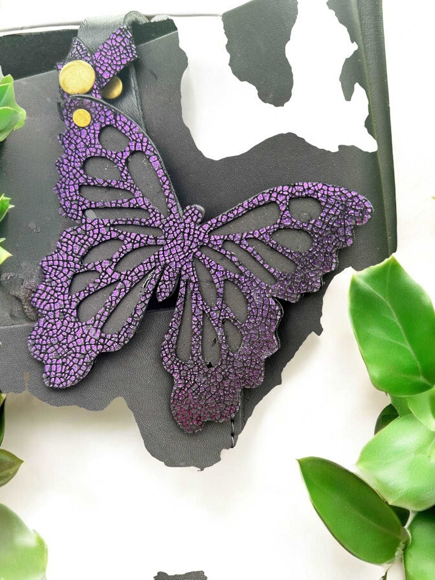 Elegant leather butterfly charm in a deep purple/grape color, crafted from halo metallic leather with a crackled finish, featuring a snap closure for attaching to purses or accessories.