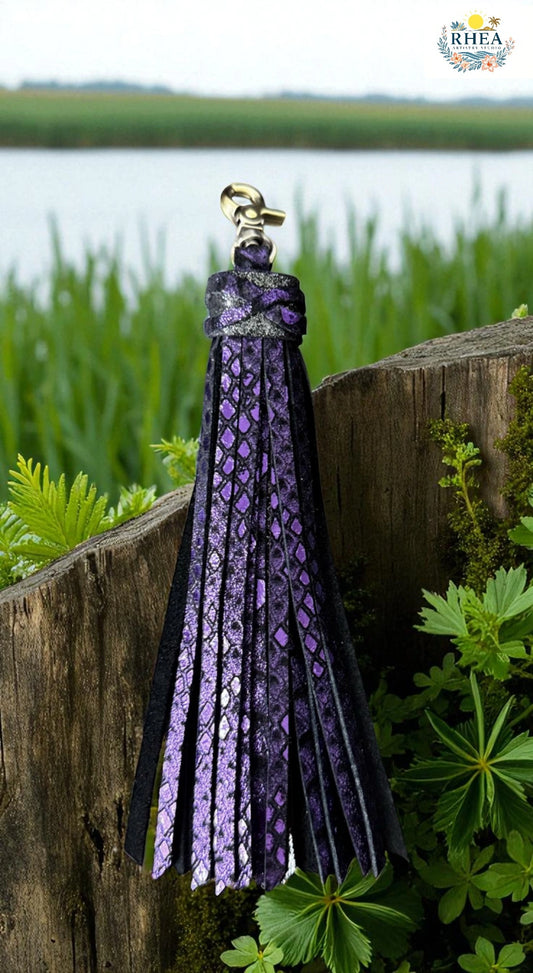 Purple and black patterned tassel on a wooden post with a natural background