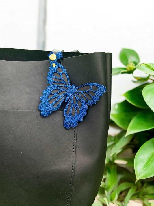 Handcrafted leather butterfly charm in a rich royal blue hue, made from halo metallic leather with a crackled look, designed with a snap closure for versatile use.