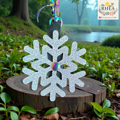 Silver glittery snowflake ornament on a wooden stump with a scenic background