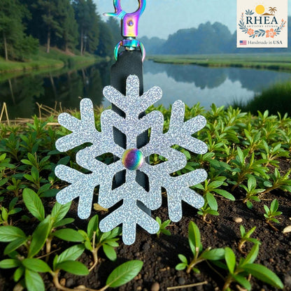 Close-up of handmade leather snowflake charm showing cutout design and texture in rainbow hardware