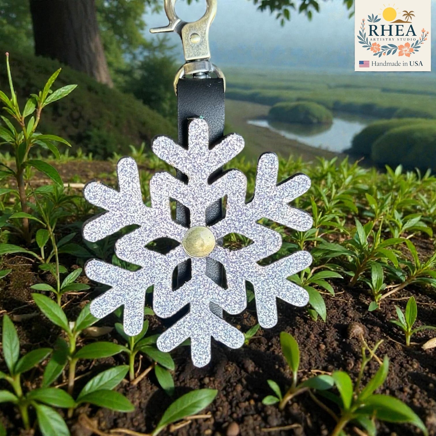 Decorative snowflake keychain on a plant with a scenic background