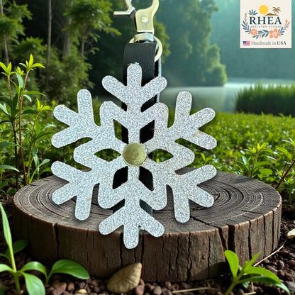 Decorative snowflake keychain on a wooden stump with a natural background