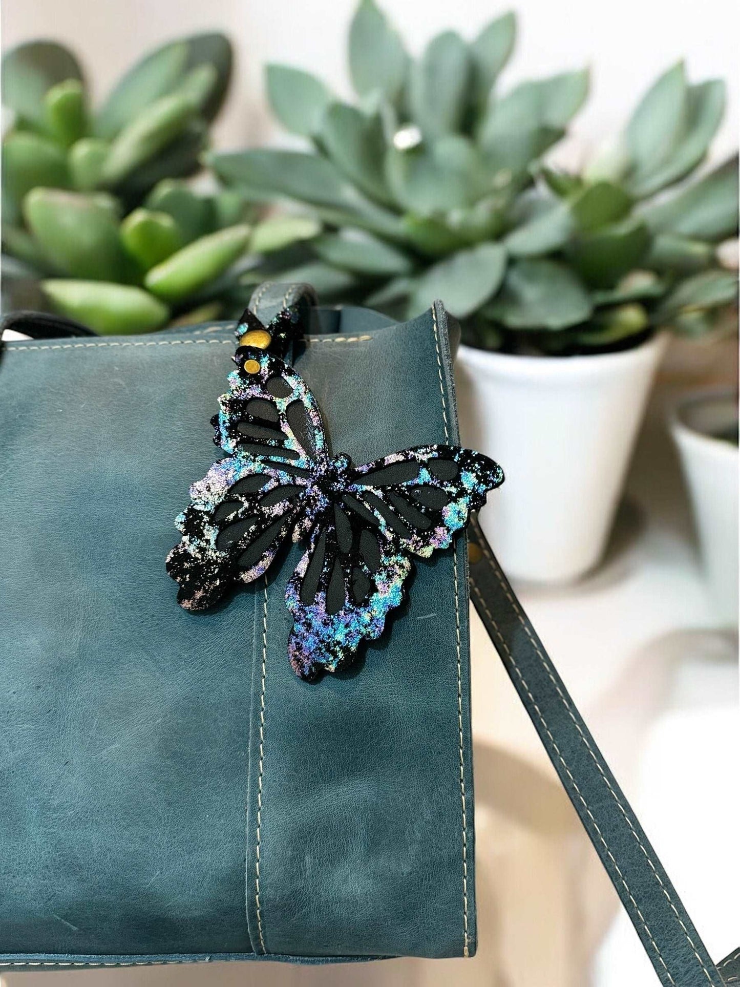 Beautiful leather butterfly charm inspired by the Spectrum Northern Lights, featuring a multicolored iridescent and metallic crackled effect, with a snap closure for easy attachment.