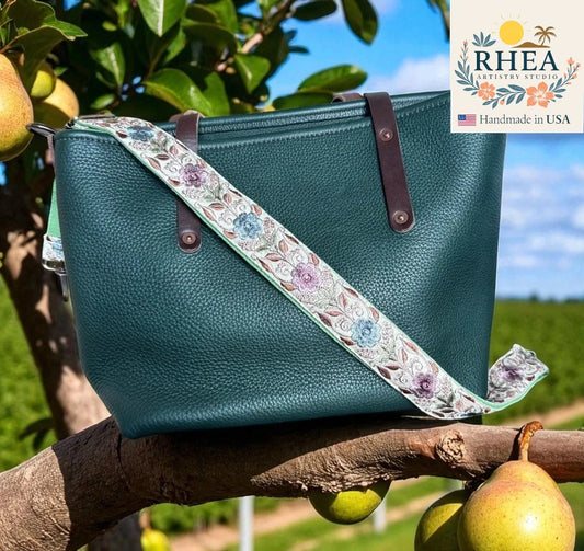Teal handbag with floral strap on a branch with pears, RHEEA branding visible