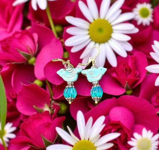 Pair of earrings with turquoise stones on a background of pink and white flowers
