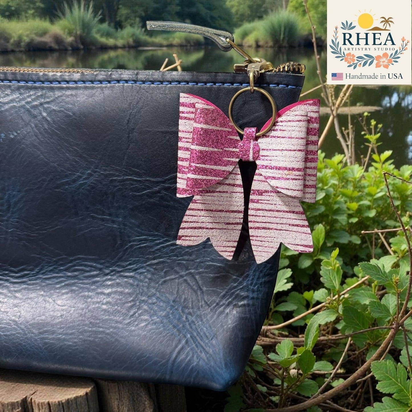 Butterfly-shaped bag charm attached to a black leather bag with a natural background