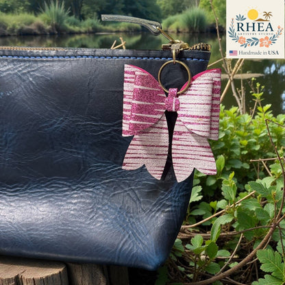 Butterfly-shaped bag charm attached to a black leather bag with a natural background