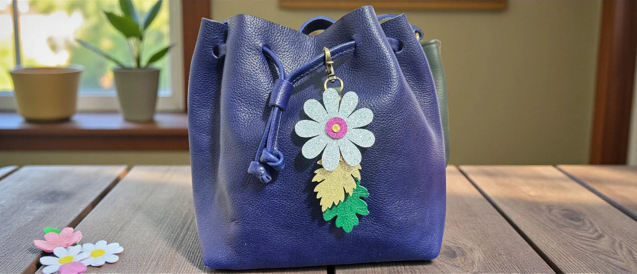 Blue handbag with floral charm on a wooden surface