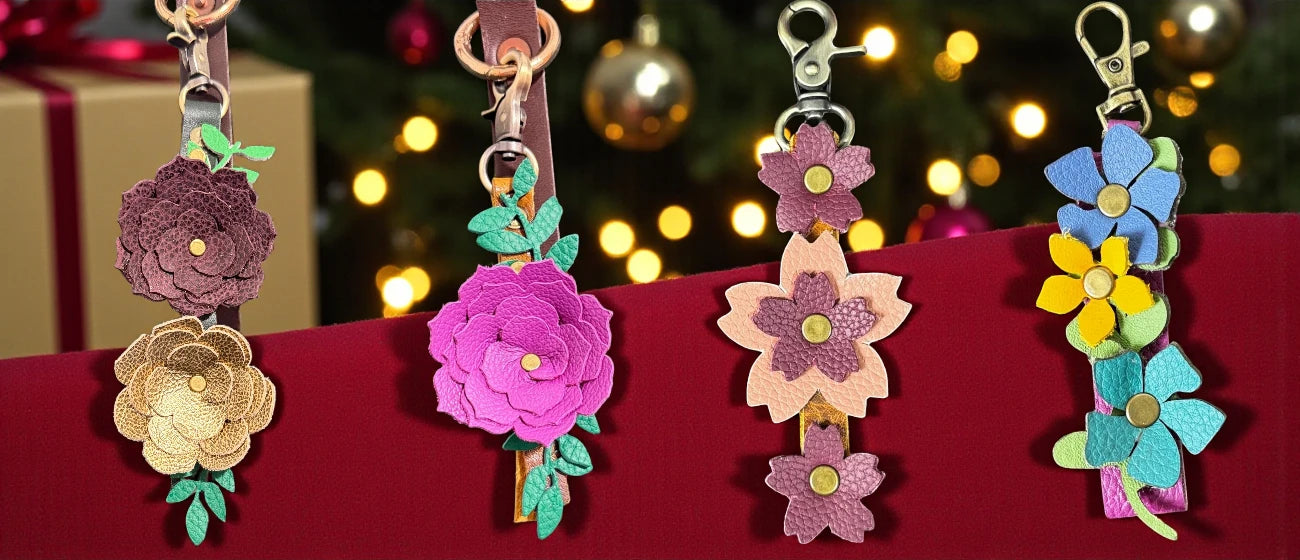 Colorful flower-shaped keychains on a red surface with blurred lights in the background
