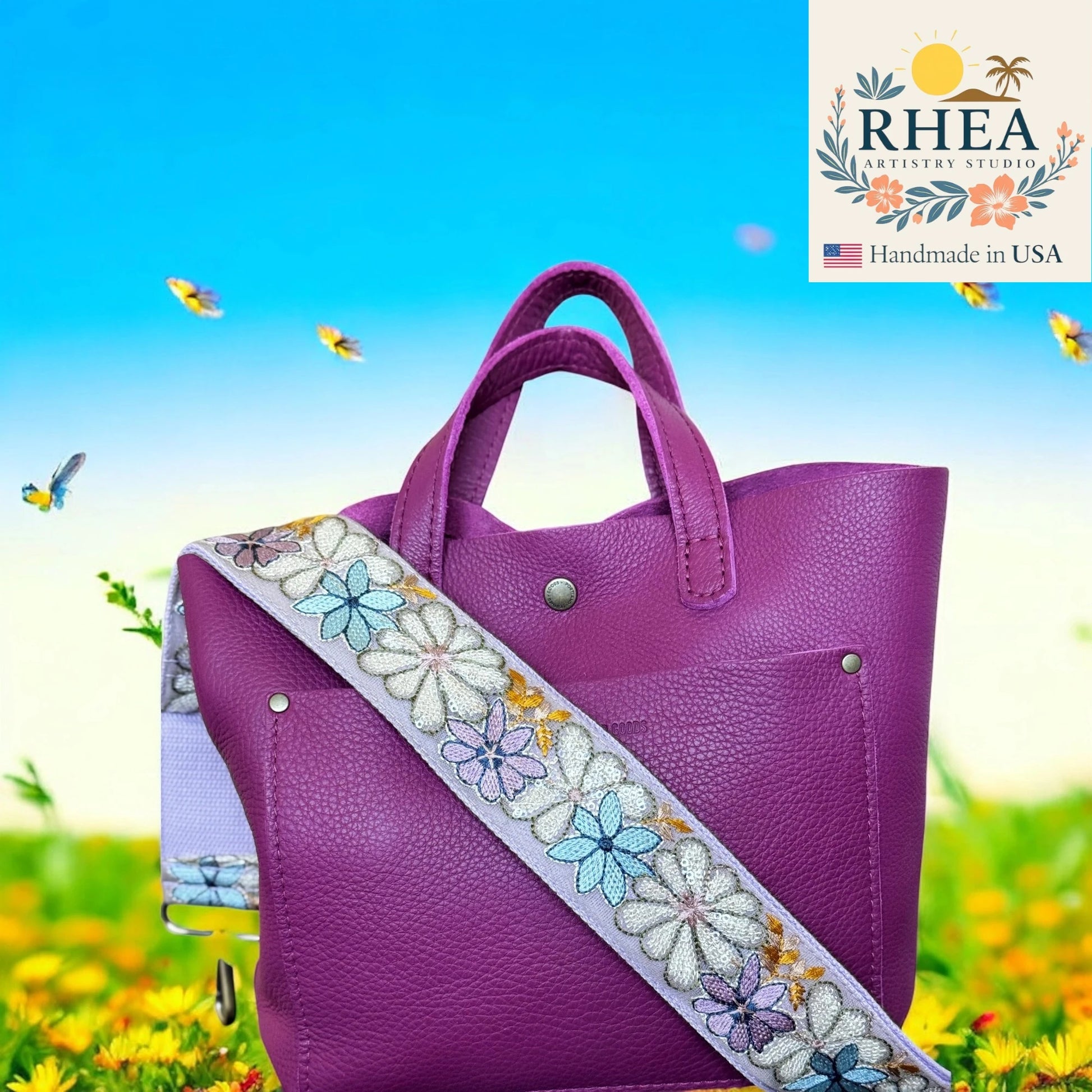 Purple handbag with a floral strap against a colorful background, featuring the RHEA Artistry Studio logo.