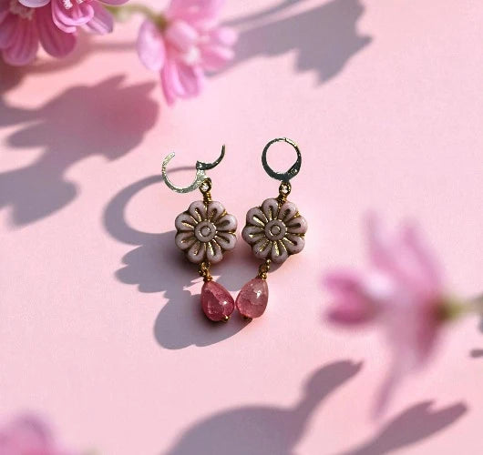 Floral earrings with pink beads on a pink floral background
