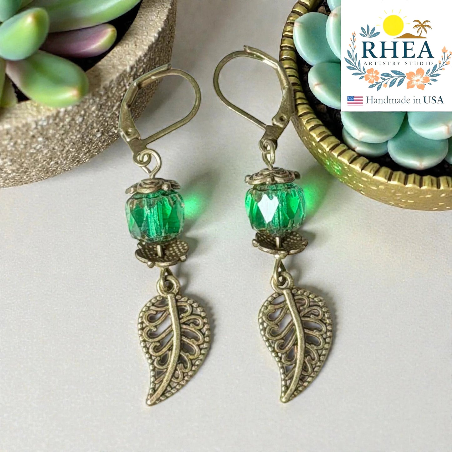 Artisan glass earrings featuring decorative brass leaf charm