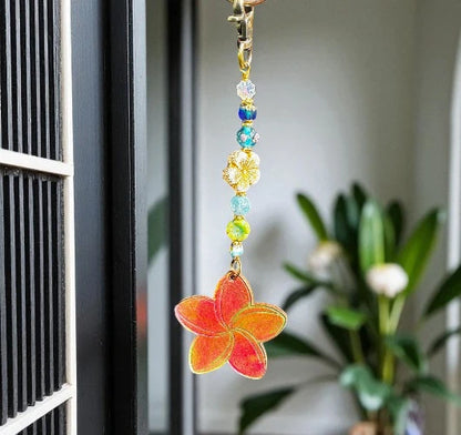 Decorative keychain with colorful beads and a red flower charm hanging on a door.